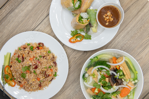 Choices of different Vietnamese tofu spring rolls, fried rice, and pho arranged on a table for presentation