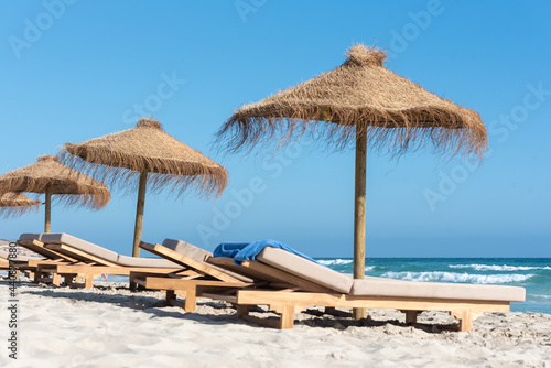 Fototapeta Naklejka Na Ścianę i Meble -  Deck chairs and straw umbrellas on the wonderful island of Formentera in Spain