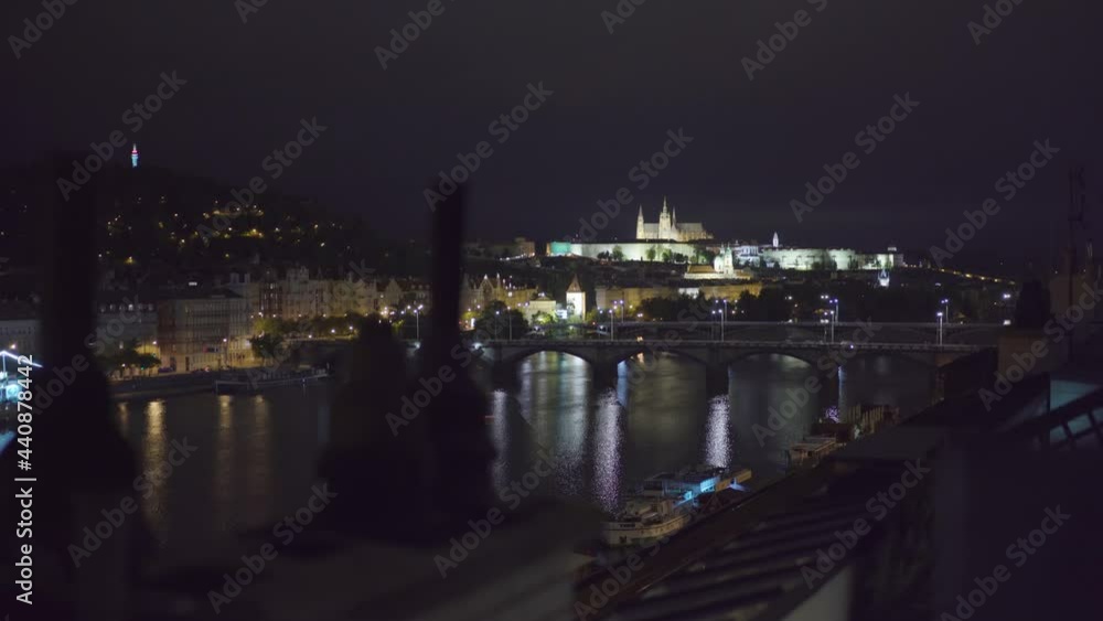 view of Prague castle and Vltava river from a rooftop at night view of Prague castle and Vltava river from a rooftop at night