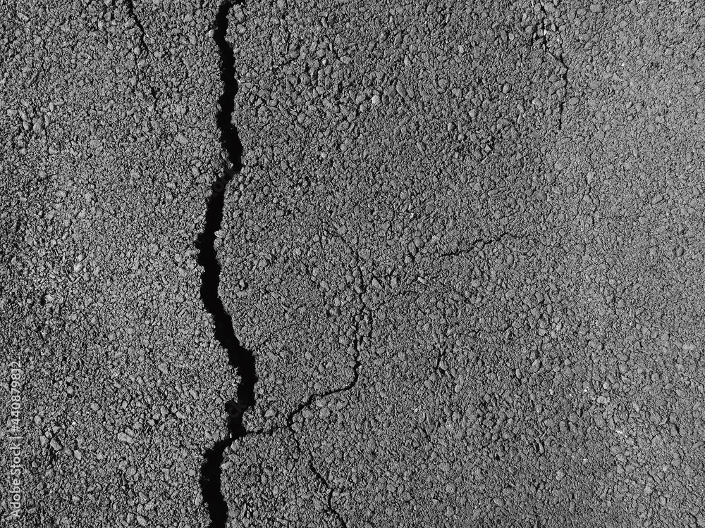 Obraz premium Old worn and cracked asphalt with cracks
