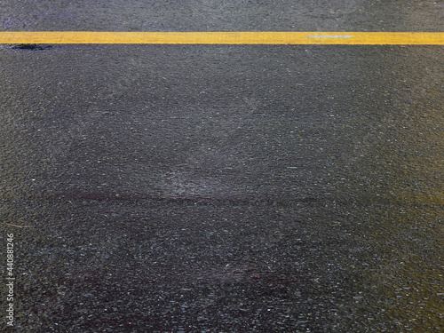 wet asphalt road with yellow line after rain