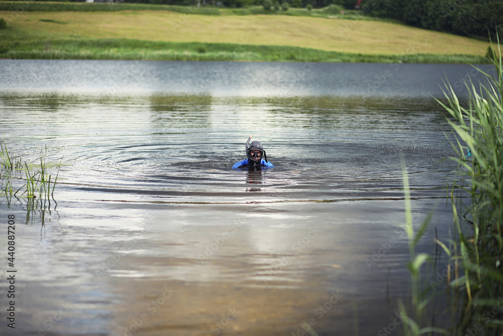 A scuba diver in a wet suit prepares