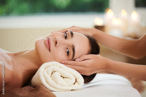 Portrait of young woman looking at camera while getting massage