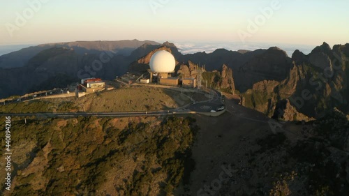 Drone aerial footage flying over Pico do Arieiro, and the radar station on the peaks at sunrise with surrunding mountains of Maderia. photo