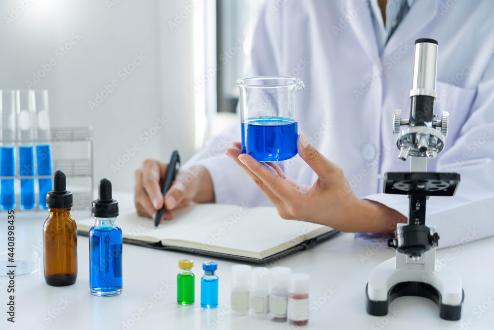 Fototapeta premium Scientist wear lab coat and protective wear are working with research or doing investigations with test tubes in experiment, Laboratory and development concept