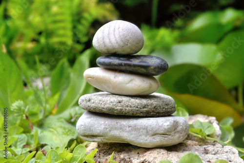 pile of pebbles in a gardenwith green foliage background photo