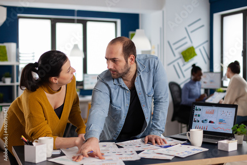 Businessman entrepreneur consulting with colleague working with charts during briefing. Diverse team of business people analyzing company financial reports from computer.