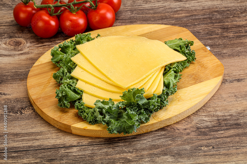 Sliced Gauda cheese over board Sliced Gauda cheese over board