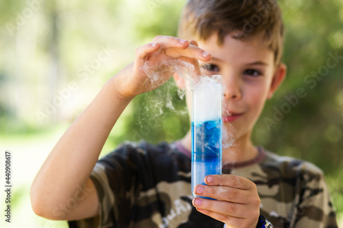 6school kid doing science experiment with dry ice, water and soap photo
