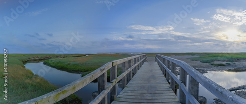 View of bridge over salt marsh channel and mud flat in Sankt Peter Ording at the Südstrand.