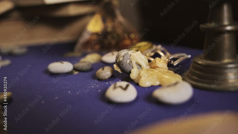 Astrology and esotericism. Wax drips on the table with runes, close-up. The background in the blur. Astrology and esotericism. Wax drips on the table with runes, close-up. The background in the blur.
