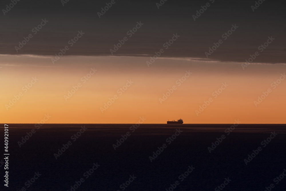Sunset over the Irish Sea from Penmaenmawr, Wales with a silhouette containers ship on the horizon. Concept is Peace and serenity