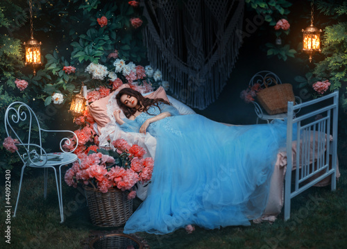 fantasy woman sleeping beauty lies sleep on comfortable bed, mattress, soft pillow. Background mystical garden, night, peonies flowers green trees. Fairy-tale girl princess in blue dress. Sweet dreams