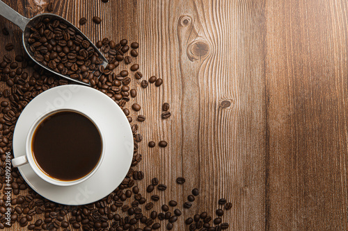 Cup of coffee and coffee beans on old wooden background