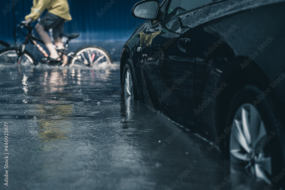 car in a deep puddle. downpour in the city. flooded car. flood in the city. - obrazy, fototapety, plakaty 