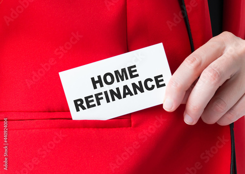 A feminine hand is holding a business card with the inscription Home Refinance. Business concept photo