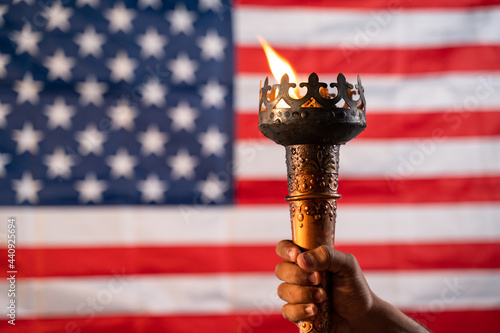Konstfotografi Close up of hands holding Olympic flame torch with US or American flag as backgr