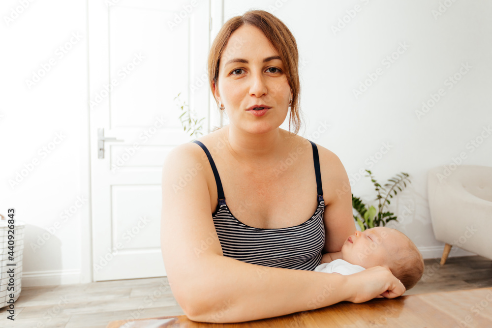 Dreamful woman with cute baby sleeping in arms Dreamful woman with cute baby sleeping in arms