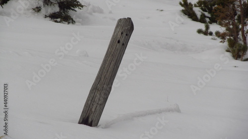 Drewniany słupek na tle śniegu w górach