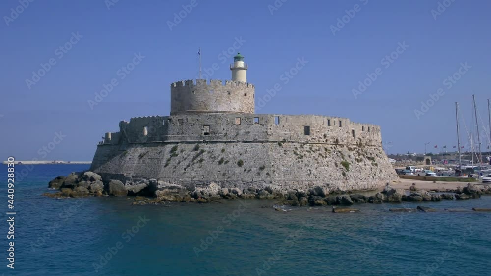 Ancient tower protecting the port entrance, view from a moving ship. Rhodes, Greece. Ancient tower protecting the port entrance, view from a moving ship. Rhodes, Greece.