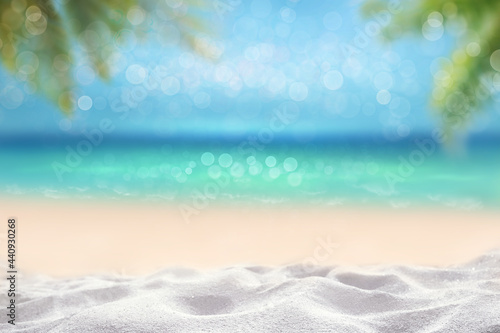 summer time tropical blurry seascape with sandy beach and wooden table top and blur palm leaves montage photo of Summer beach concept