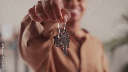 Close up of dark skinned female tenant renter show praise house keys moving to first own new apartment or house, happy woman owner buy purchase home relocate to dwelling rental rent ownership concept.
