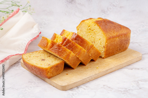 Sliced pound cake with lemon glaze on a cutting board.