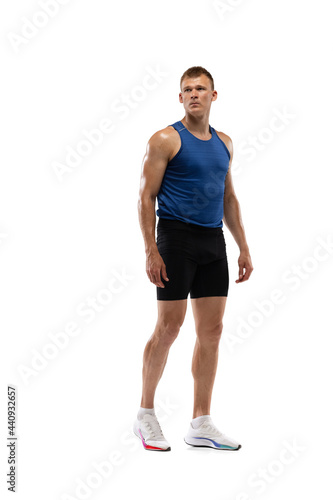 Caucasian professional male athlete, runner standing isolated on white studio background. Muscular, sportive man.