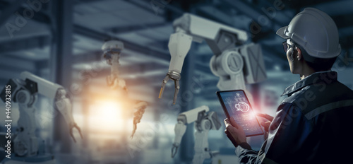 Engineer check and control robotics automatic arms machine in intelligent and smart factory automotive industrial on real time monitoring system software. Digital manufacturing operation. Industry 4.0