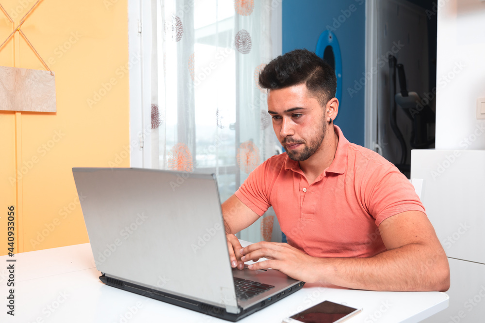 Young man working at home with a laptop. Young man working at home with a laptop.