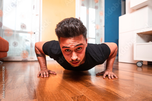 Young caucasian man doing push-ups at home