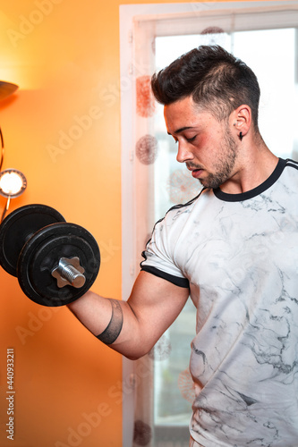 Young caucasian woman raising weights at home.