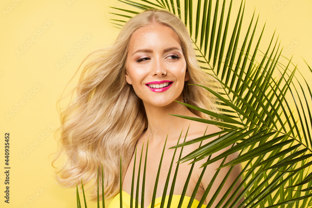 Summer Blonde Girl Portrait over Yellow in Tropic Palm Leaves. Happy Smiling Young Woman enjoying Sunbath. Body and Face Skin Sun Care. Summertime Curly Hairstyle and Makeup Summer Blonde Girl Portrait over Yellow in Tropic Palm Leaves. Happy Smiling Young Woman enjoying Sunbath. Body and Face Skin Sun Care. Summertime Curly Hairstyle and Makeup