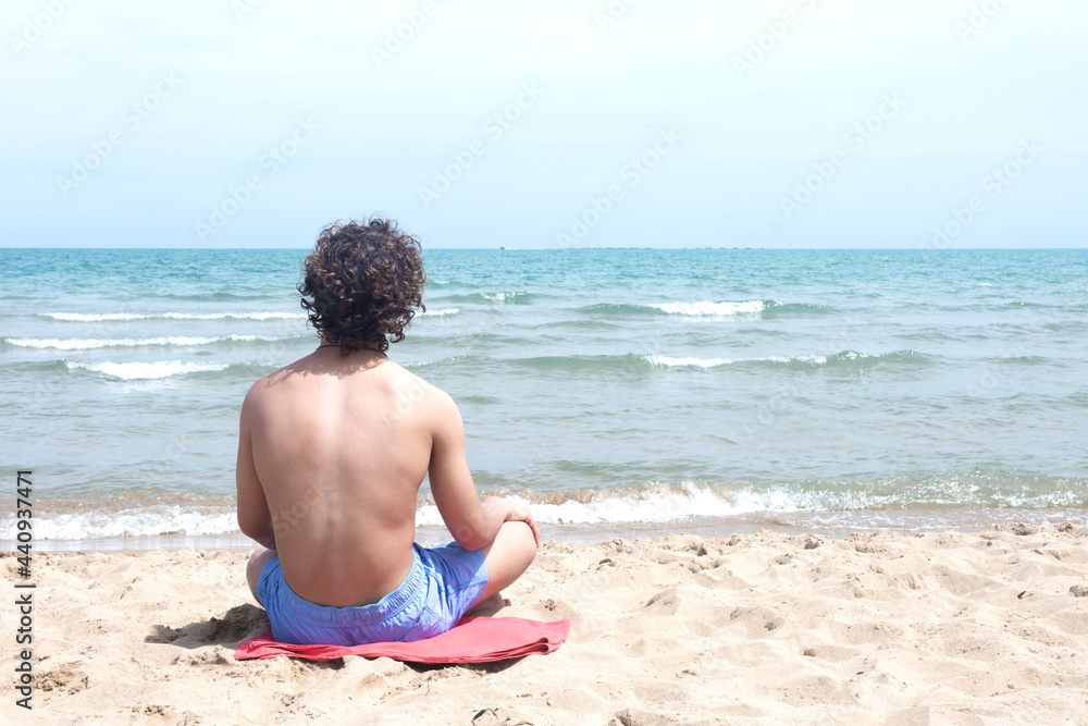 Young surfer looking at the waves from the shore Young surfer looking at the waves from the shore