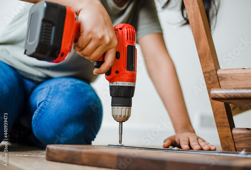 Canvastavla Woman using hand drill to assemble a wooden table