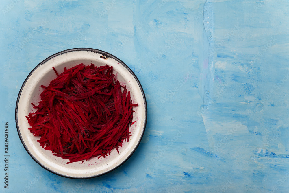 Bowl of beetroot cut into thin strips on blue painted wooden background. Vegetarian, organic, healthy food, diet, nutrition. Top view, copy space. Bowl of beetroot cut into thin strips on blue painted wooden background. Vegetarian, organic, healthy food, diet, nutrition. Top view, copy space.
