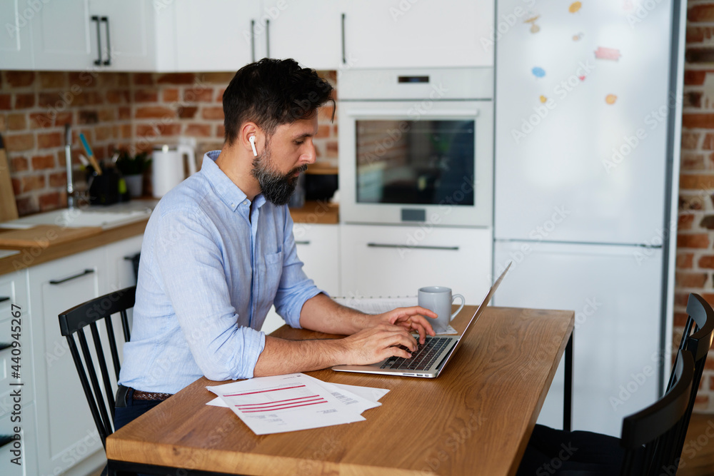 Casual businessman in home office working at his laptop. Casual businessman in home office working at his laptop.