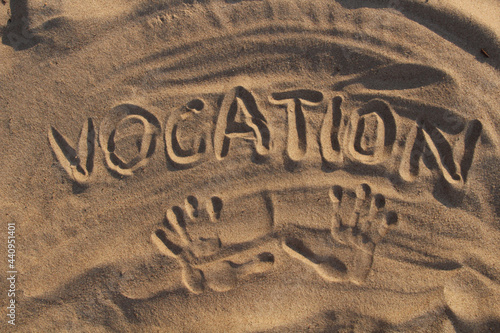 Sand on the beach and the inscription vacation