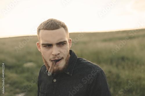 man in the field smoking cigar