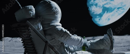 Back view of lunar astronaut opens a beer bottle while resting in a beach chair on Moon surface, enjoying view of Earth. Shot with 2x anamorphic lens