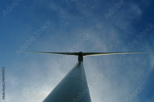 Silhouette of a wind turbine against a blue sky. photo