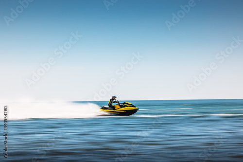 Summer fun by the sea, girl ride a jet ski in spray of water © ValentinValkov