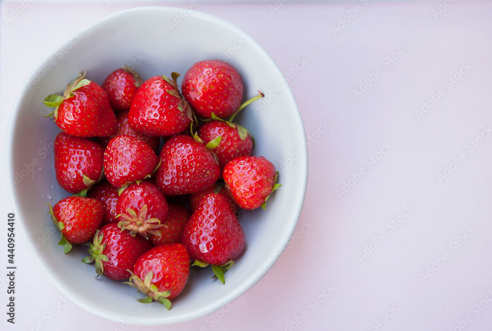 Top view shot of delicious fresh strawberries in a bowl on pastel background, copy space Top view shot of delicious fresh strawberries in a bowl on pastel background, copy space