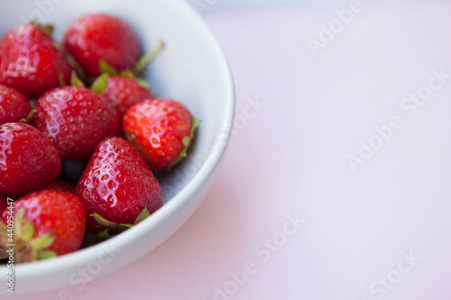 Cropped shot of a bowl with strawberries on pastel background, copy space