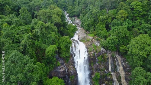 Aerial view of Wachirathan Waterfalls, beautiful waterfall flowing from high cliff around with green forest background, Doi Inthanon National Park, Chiang Mai, northern Thailand.