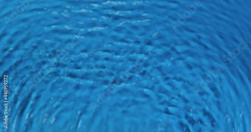 Waves in blue water, wavy movement of water. Vertical motion. Ripple lines. Top view. Water texture.