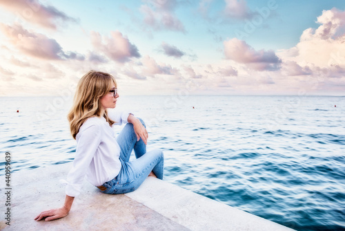 Attractive woman sitting by the sea