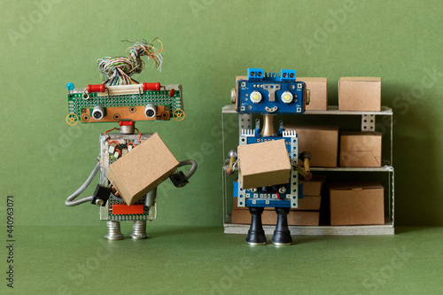 The robots storekeepers sorts goods in boxes of different sizes on the shelves of the rack. Automation of storage, delivery and sorting of shipments. Green background