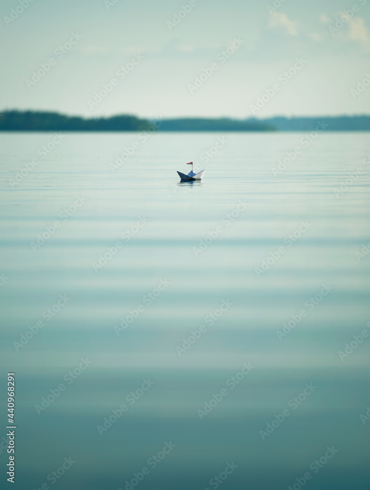 Fototapeta premium Kleines Papierschiffchen auf einem großen See