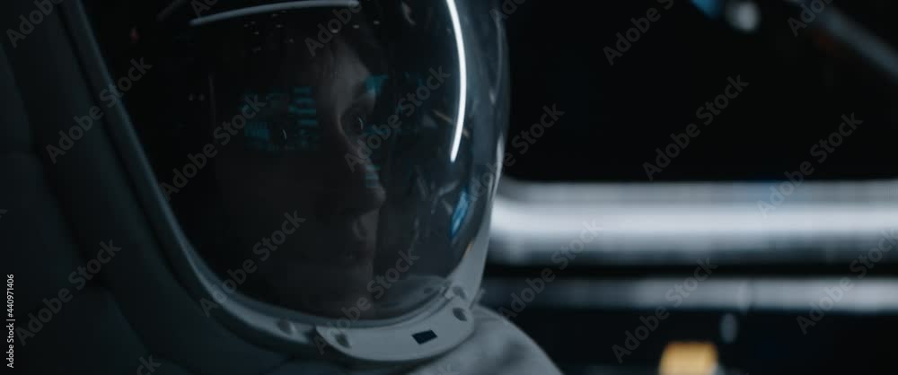 Portrait of Caucasian female astronaut inside spaceship cockpit. Sci-fi space exploration concept. Moon mission. Shot with 2x Anamorphic lens